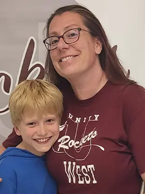 Jess is pictured next to a small child.