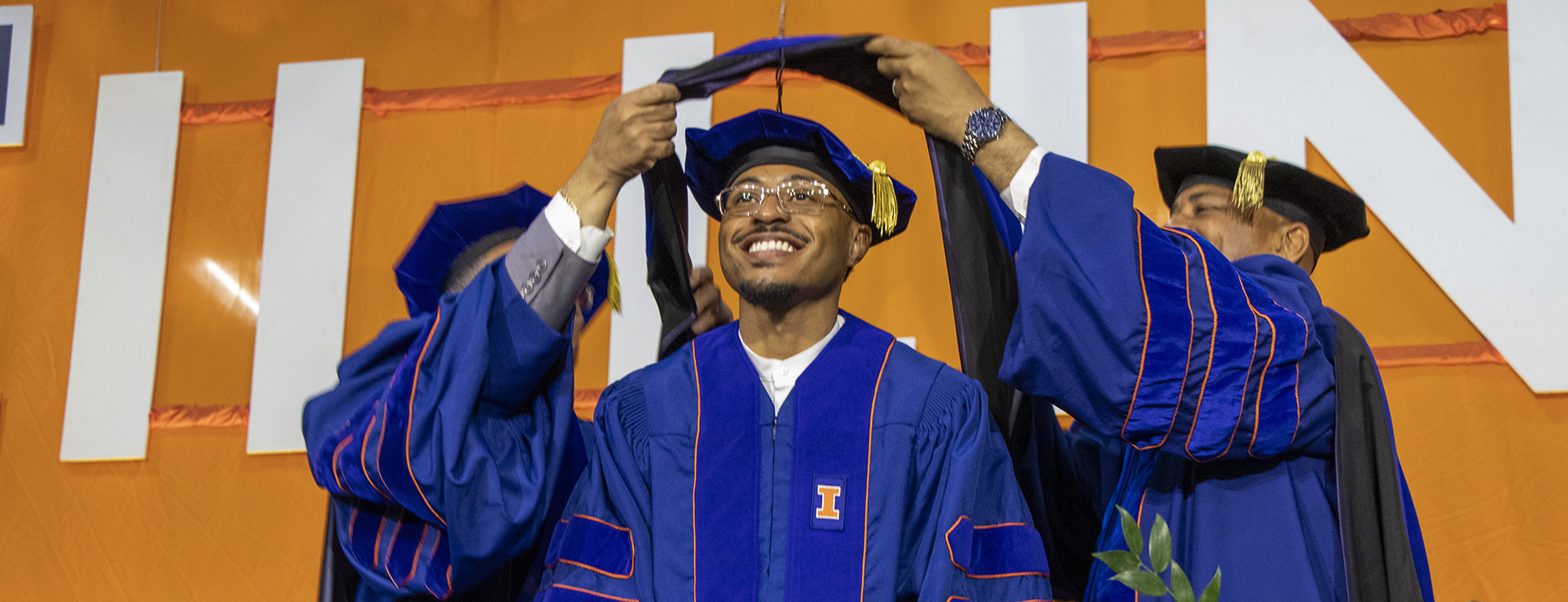 a doctoral student being hooded at convocation